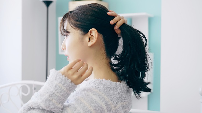 Woman putting hair in ponytail