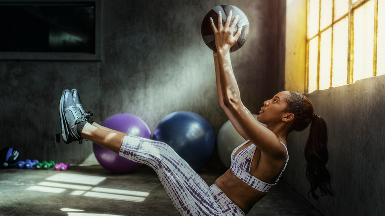 Woman holding medicine ball above head