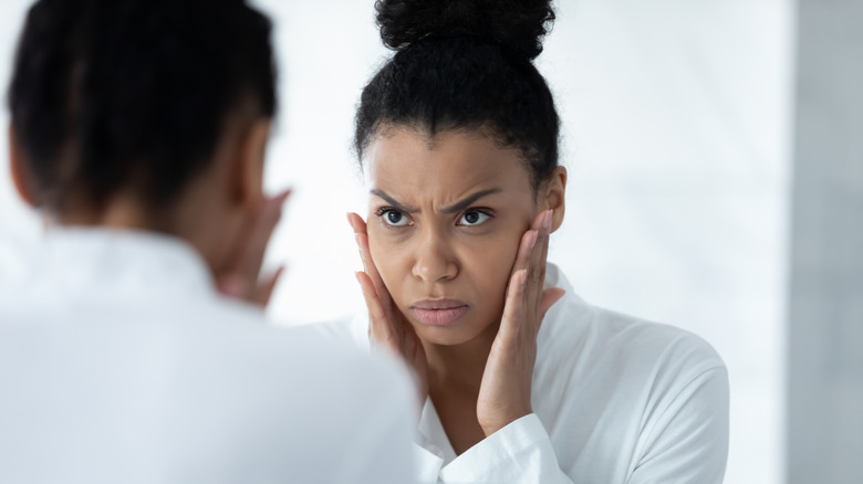 Woman making angry face at reflection