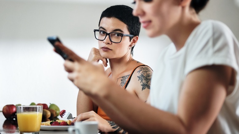 Tattooed woman looking at woman