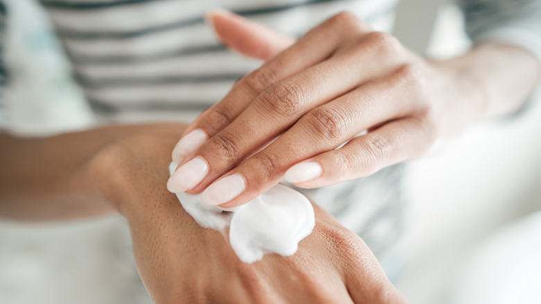 Woman's hands applying lotion