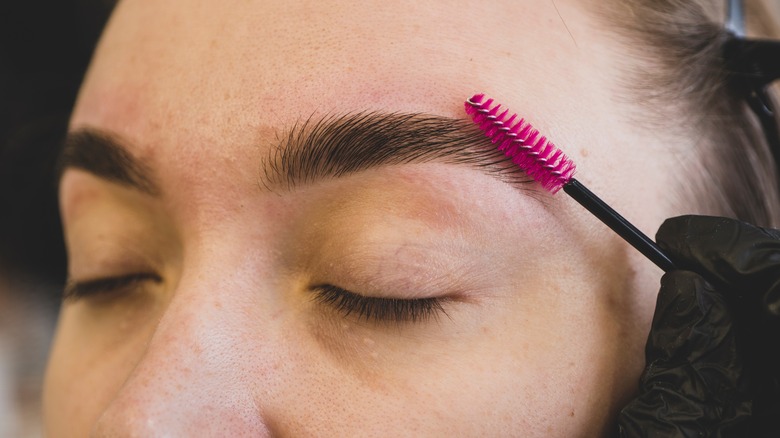 woman having eyebrows groomed