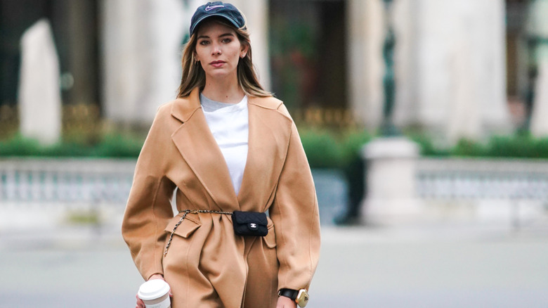 A woman wears basic textures with a white shirt and brown coat