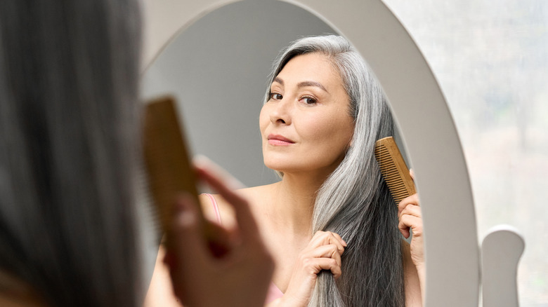 Woman brushing her hair with a comb