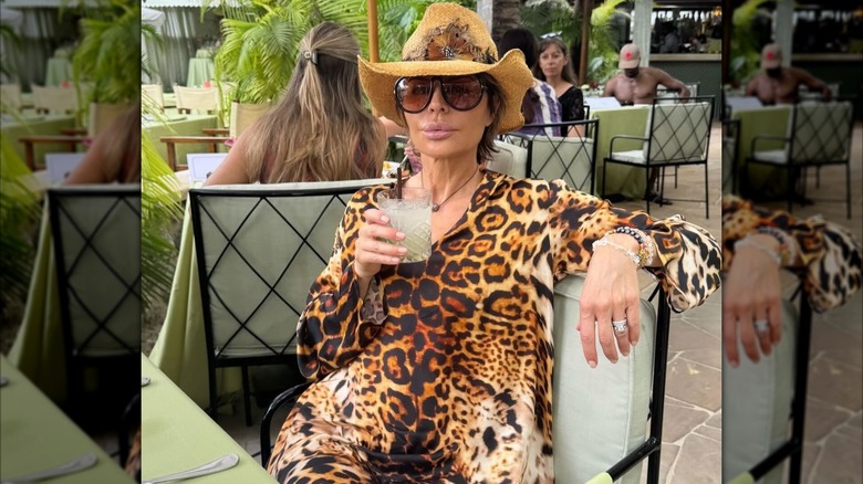Lisa Rinna poses for a photo with a drink in her hand at a restaurant