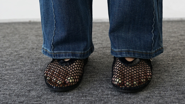 Woman in blue jeans wearing mesh synthetic shoes
