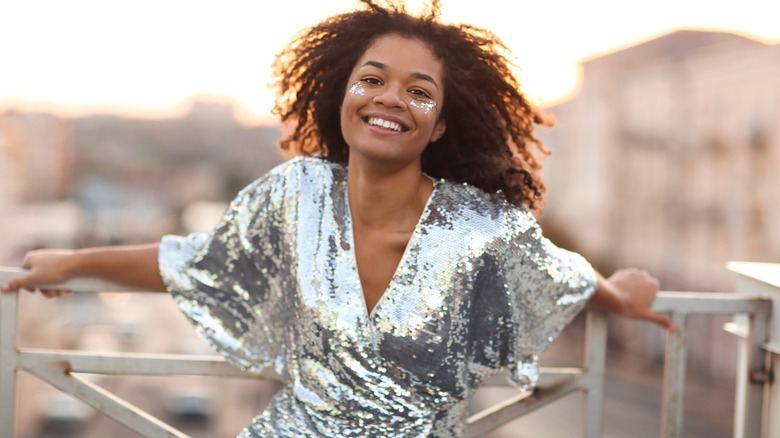 smiling woman wearing glitter dress