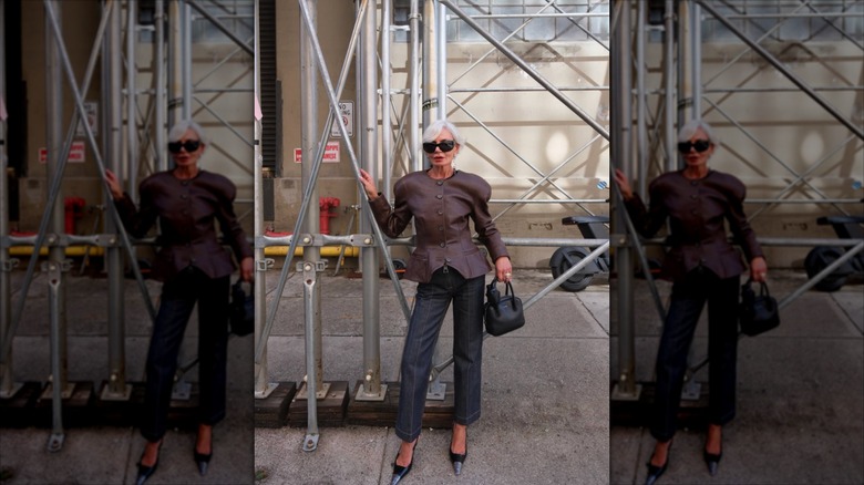 Grece Ghanem wearing a shoulder-padded blazer, bold sunglasses, and pointed heels
