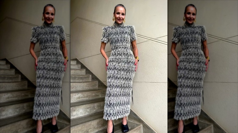 Yasmin Furmie wearing a maxi dress that features a feathered texture and gold jewelry