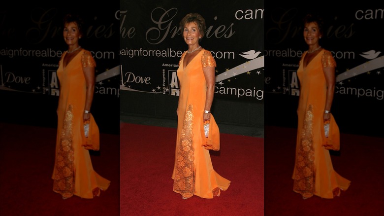 Judy Sheindlin wearing a vibrant orange lace-trimmed gown.