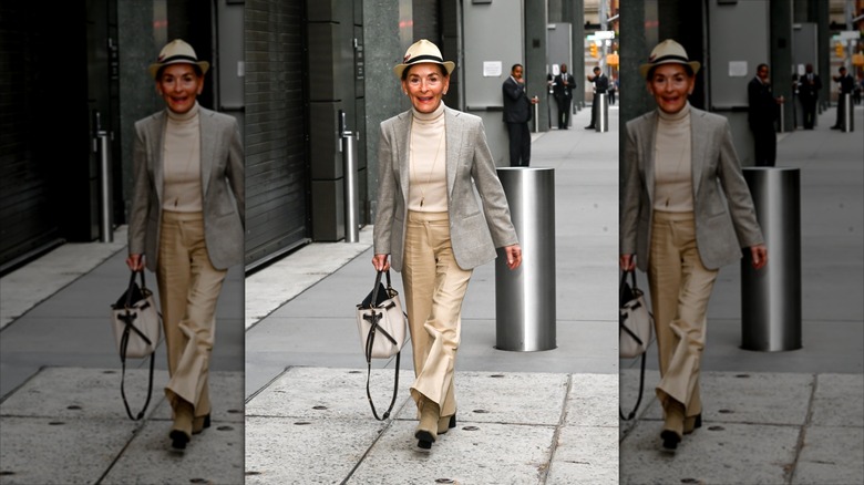 Judy Sheindlin wearing a beige-and-black fedora with a cream turtleneck with a gray blazer.
