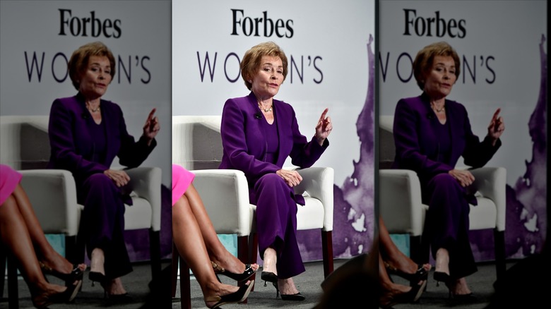 Judy Sheindlin wearing a plum pantsuit.