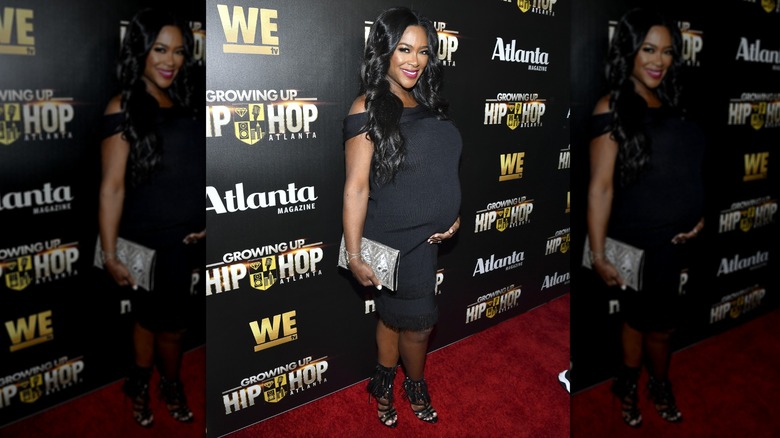 Kenya Moore wearing a stretchy black dress while pregnant