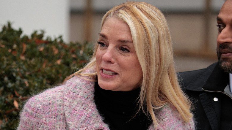 Pam Bondi wears a pink coat and sports chunky blond highlights