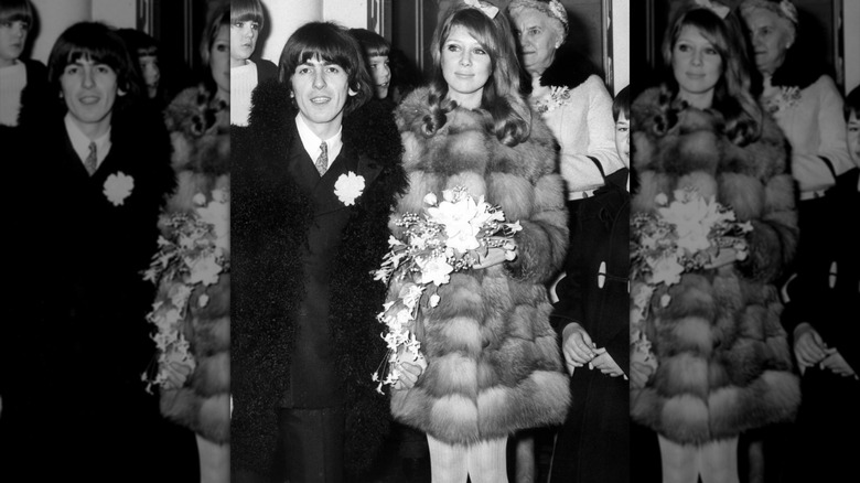 Pattie Boyd wears a skirt, coat, and long socks sitting on a bench