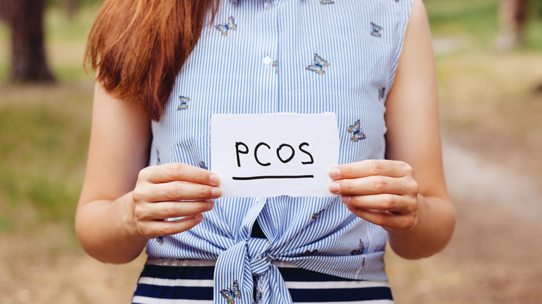 Woman holding a "PCOS" sign