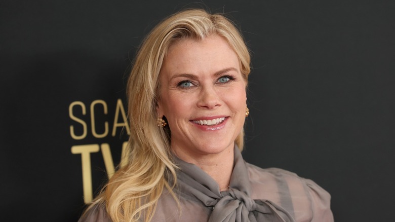 Alison Sweeney poses on the red carpet in a sheer long-sleeve gray blouse with her blond hair down in waves at the Hallmark's Power of Love panel during the 14th SCAD TVfest in Atlanta, Georgia in February 2026.