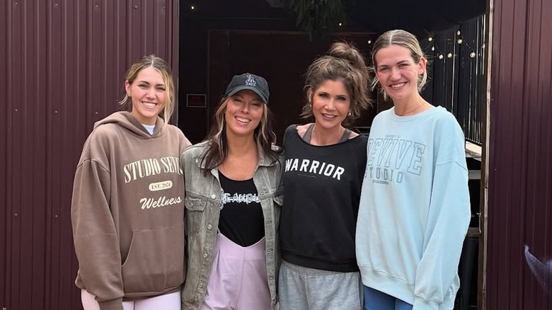 Kristi Noem poses for a photo with her daughters and a messy updo