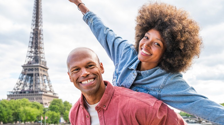 Black couple posing by Eiffel Tower