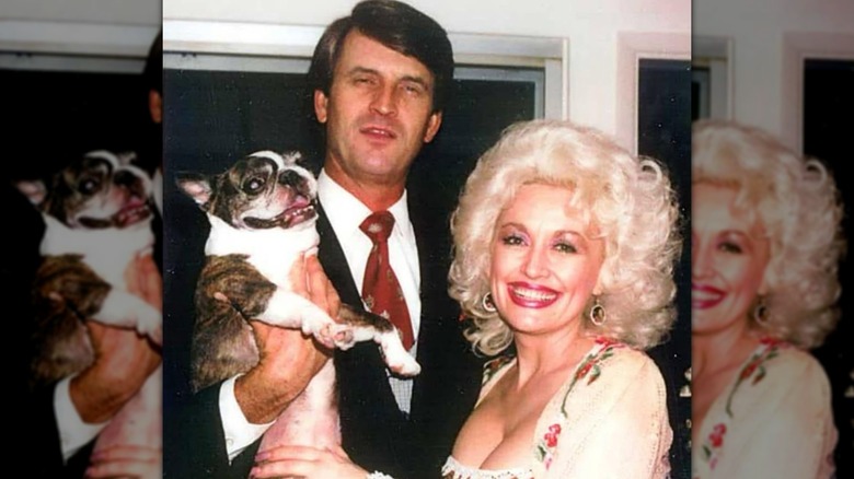 Dolly Parton and Carl Dean pose for a photo together alongside their dog, Popeye.