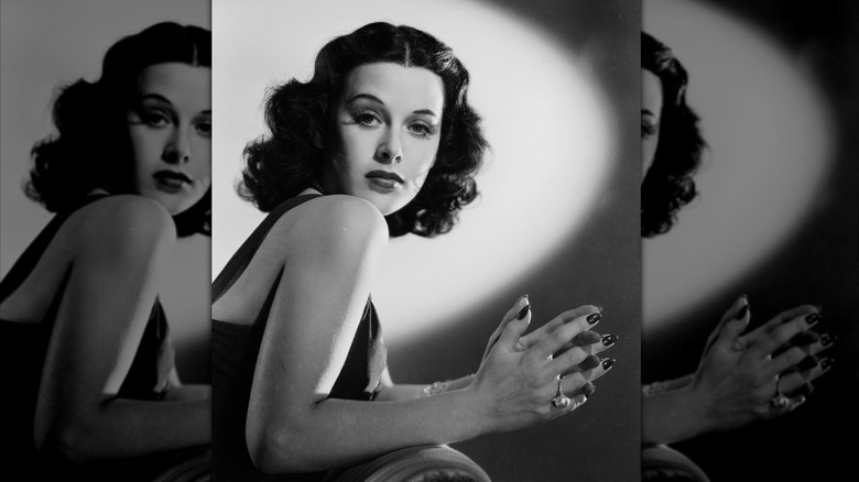Hedy Lamar poses for a 1938 photo wearing red lipstick, fluttery eyelashes, and a bold brow