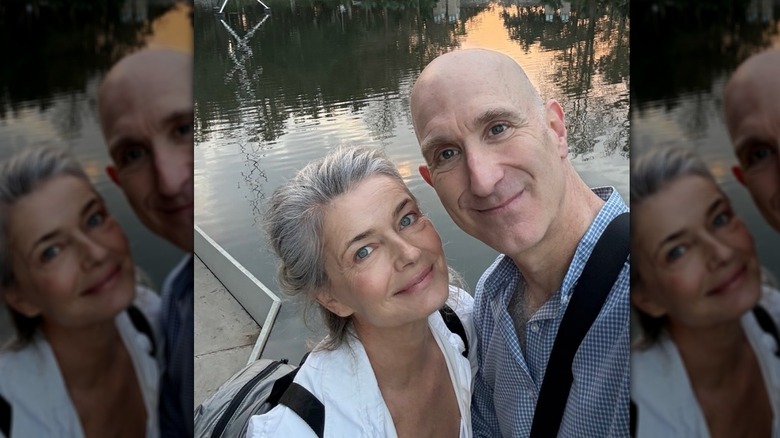 Paulina Porizkova posing next to fiance Jeff Greenstein by the water in February 2026.