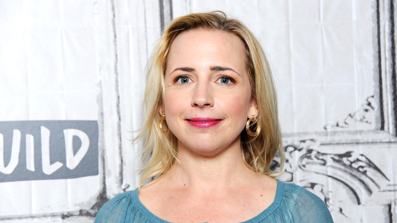 Lecy Goranson poses in front of a white background in a blue top
