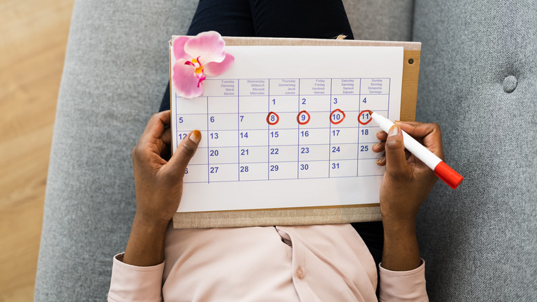 woman marking period on calendar