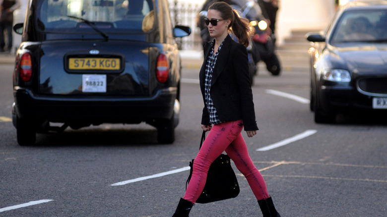 Pippa Middleton walking with hot-pink jeans, a plaid shirt, and a black blazer