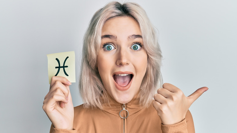 Woman holding Pisces symbol