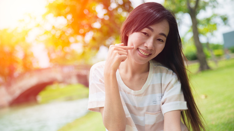 Smiling woman poking cheeks