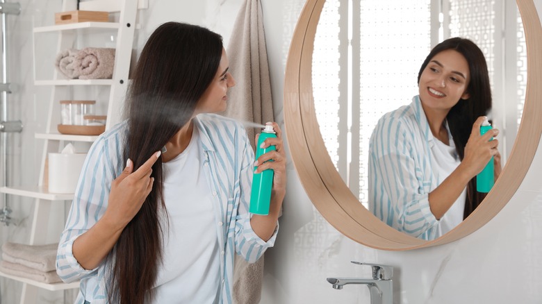 woman applying hair spray
