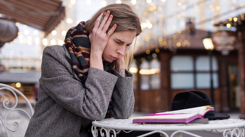 Woman holding her head unable to focus 