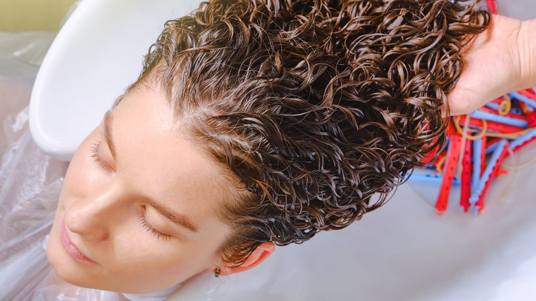 woman getting hair perm treatment