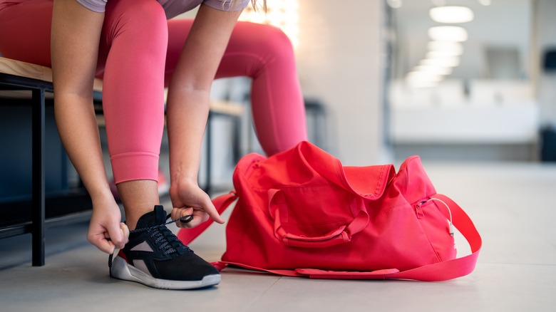 woman putting on shoe