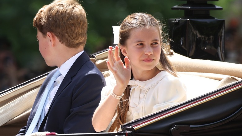 Princess Charlotte waving while riding in a car at Trooping the Colour 2026.