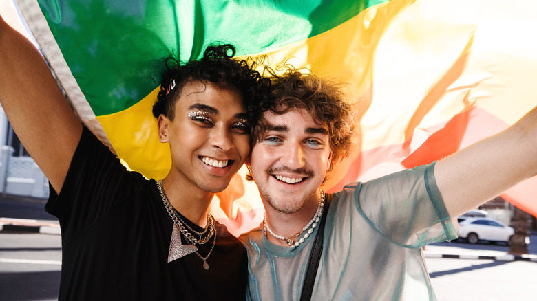 Young LGBTQ+ couple with pride flag