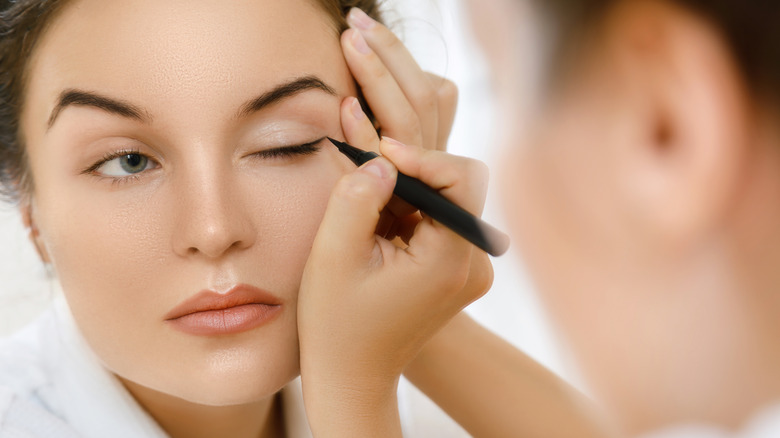 Woman applying eyeliner