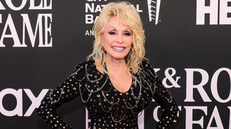 Dolly Parton wearing a black dress with big '80s-style hair