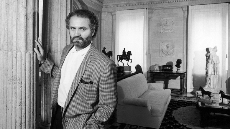 A black-and-white portrait of designer Gianni Versace.