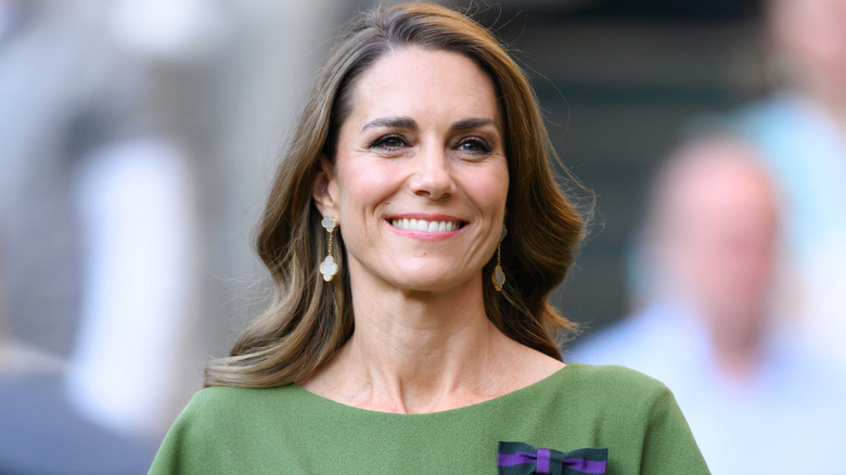 Kate Middleton smiling while wearing a green dress