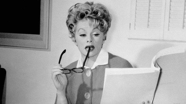 A black-and-white photo of Lucille Ball studying a script.