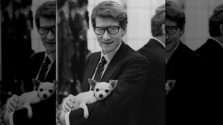 Yves Saint Laurent wearing glasses and cuddling a chihuahua
