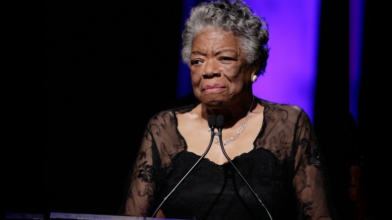 Maya Angelou stands at a podium as she addresses an audience