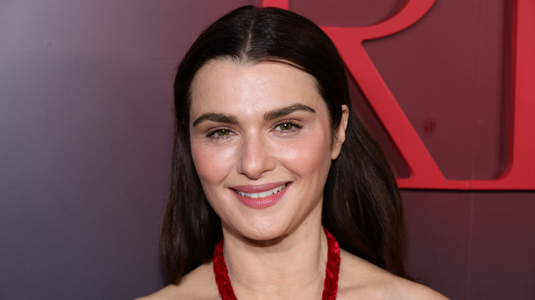 Rachel Weisz in sleek back hair and a red dress