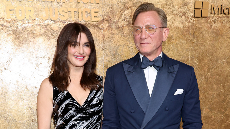Rachel Weisz wearing a printed dress posing with husband Daniel Craig