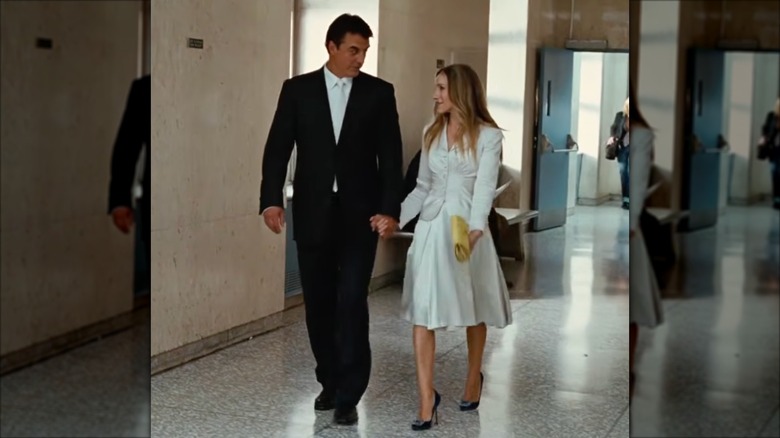Sarah Jessica Parker as Carrie Bradshaw wearing a white skirt suit.