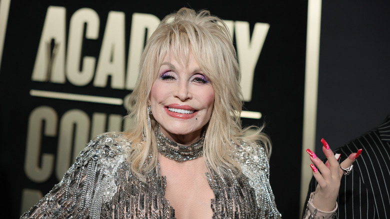 Dolly Parton smiles in a rhinestone top