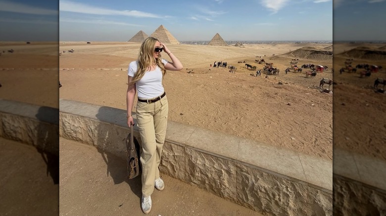 Tiffany Trump posing in a white tee and tan cargo pants near the pyramids in Egypt