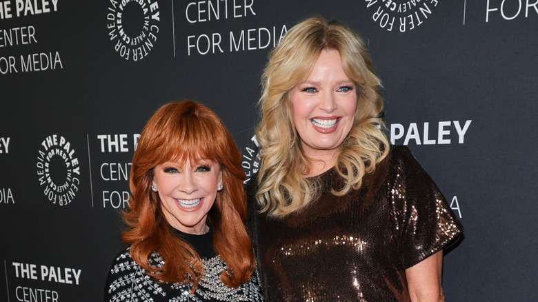 Reba McEntire and Melissa Peterman pose together smiling at a red carpet event.